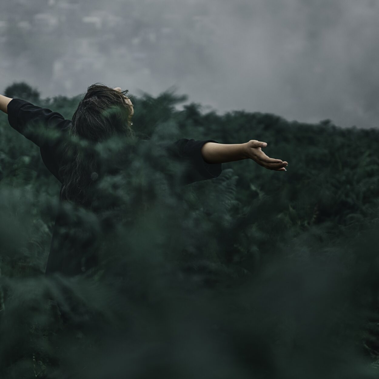 Person Standing on Grass Field While Opening Hands