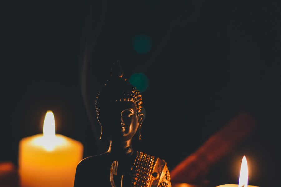 sitting buddha beside pillar candles
